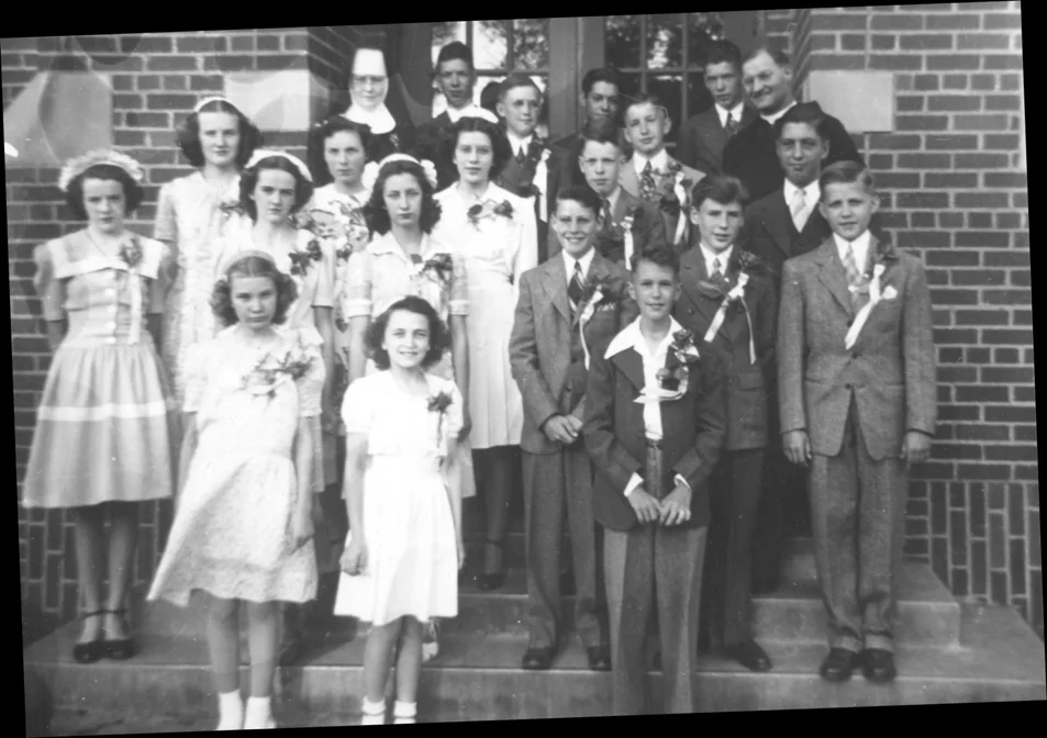 A photograph of 13 year-old girls and boys on the steps leading to an institutional entrance.