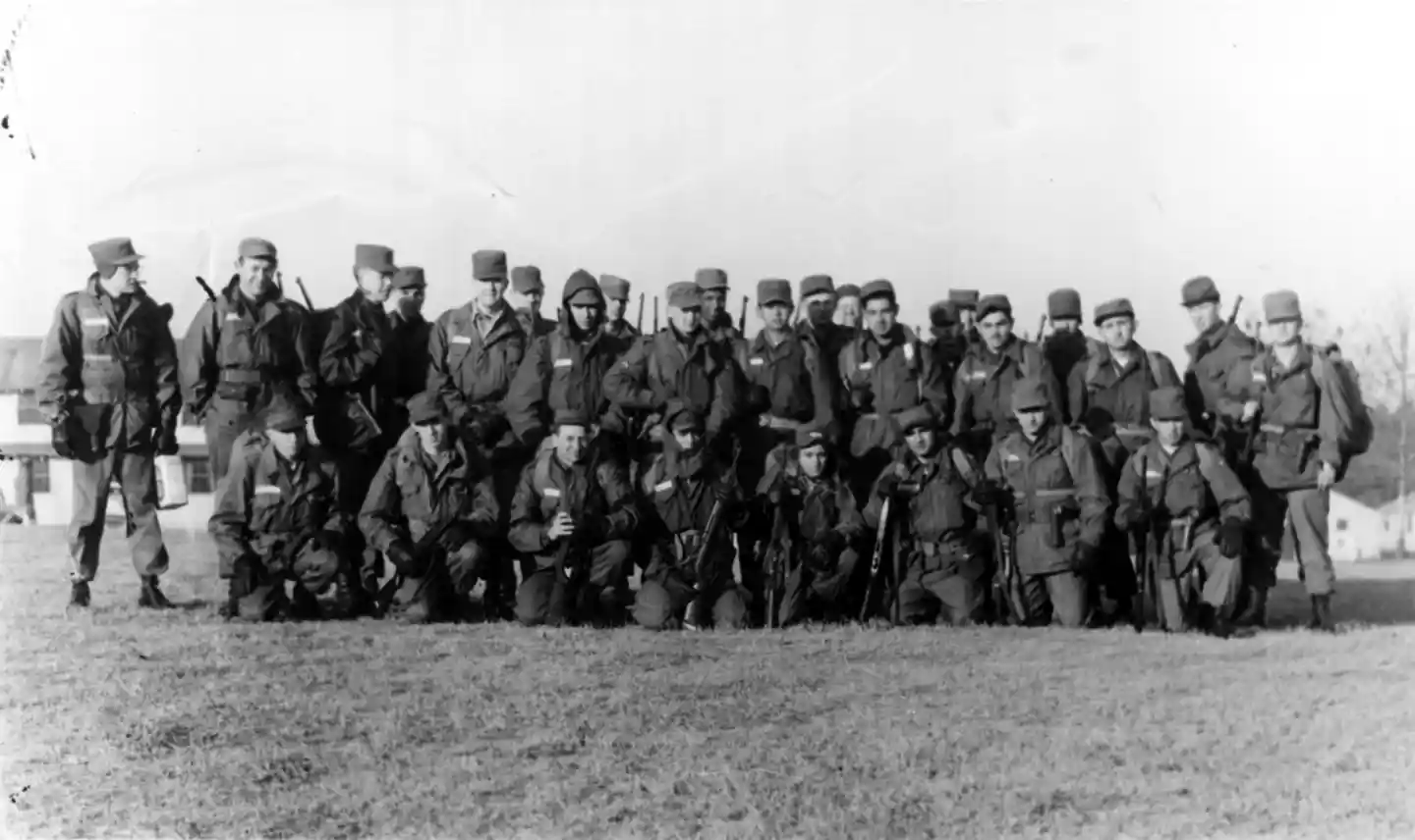 A photograph of US Army soldiers in basic training posing in a field.