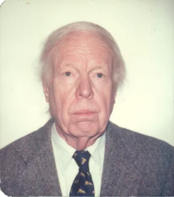 A photograph of an old white man wearing a suit and tie.